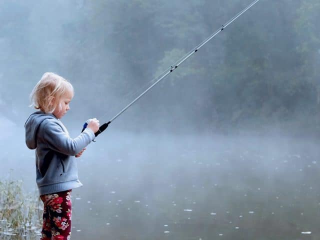 A small child fishing on a lake