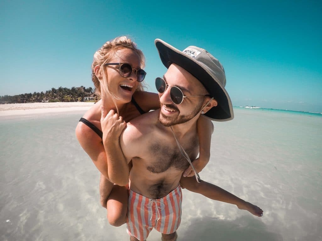 Man and woman on beach wearing sunglasses