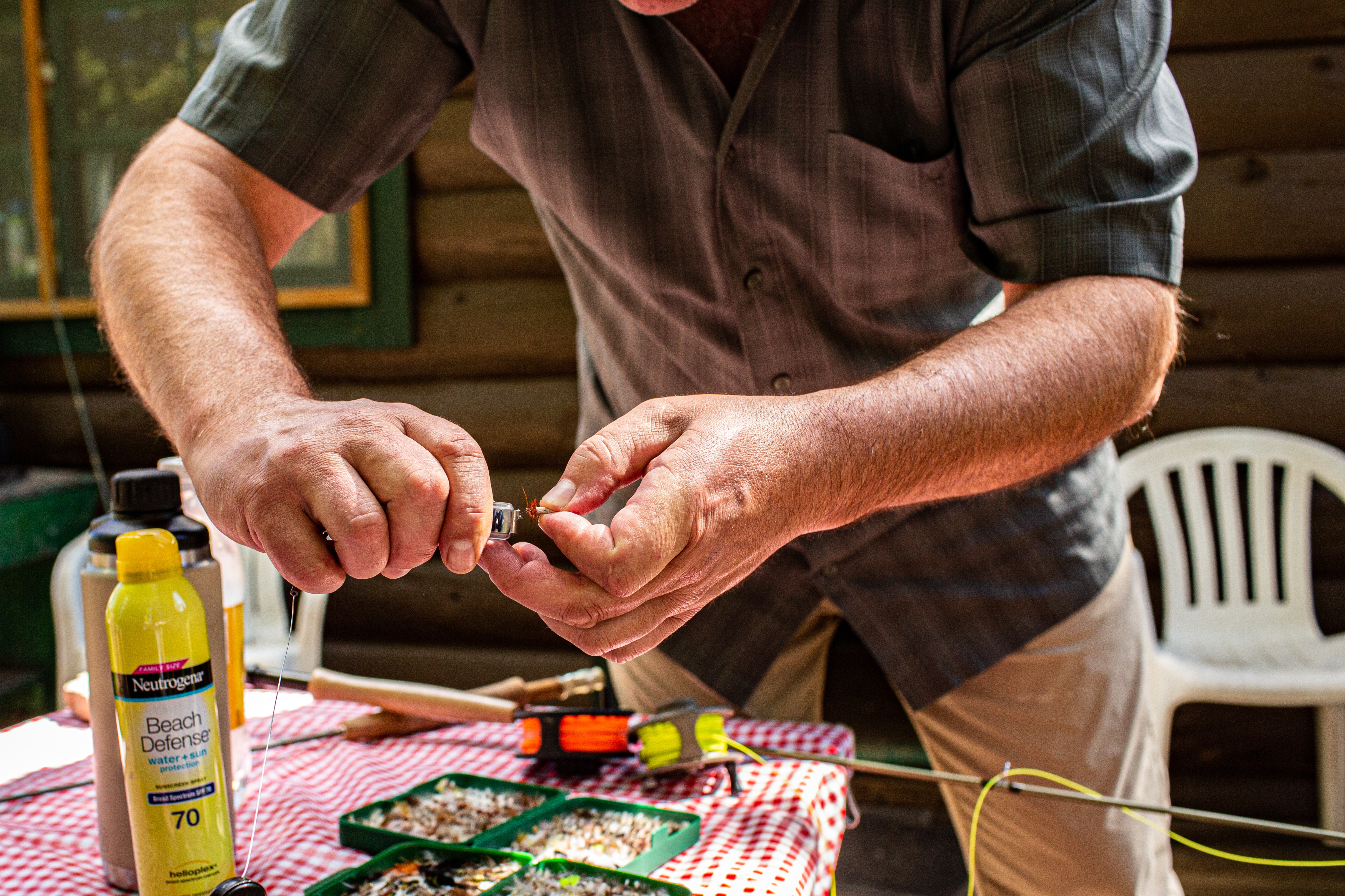 Fly angler prepping fly rod and fly reel and tying a fly