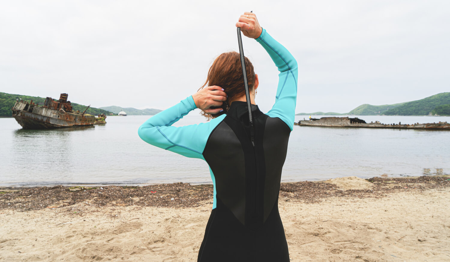 Woman Zipping Up Wetsuit